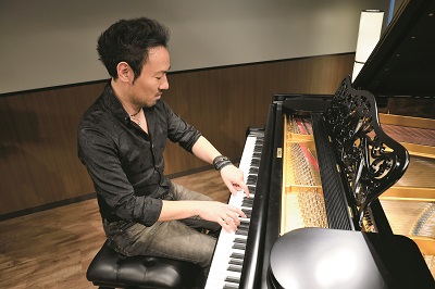 左手の親指と人差し指、右手の５本指で演奏する西川悟平氏
